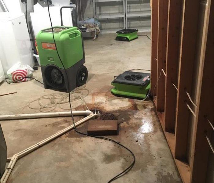 Air movers and air scrubbers on a concrete floor. 