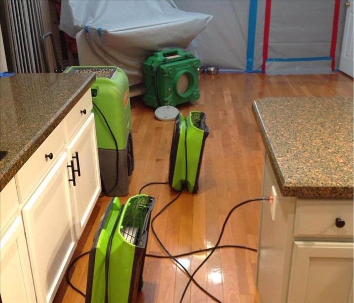 Green air movers on the floor in a hallway.