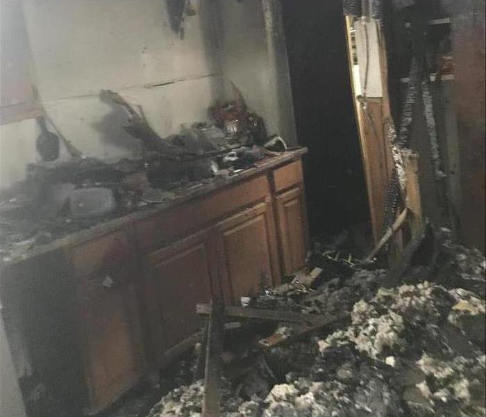 Severe kitchen fire, debris on top of kitchen cabinets and on the floor